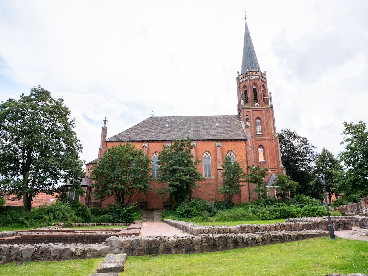 Außenansicht von Norden, im Vordergrund die Grundmauern des ehem. Benediktinerklosters