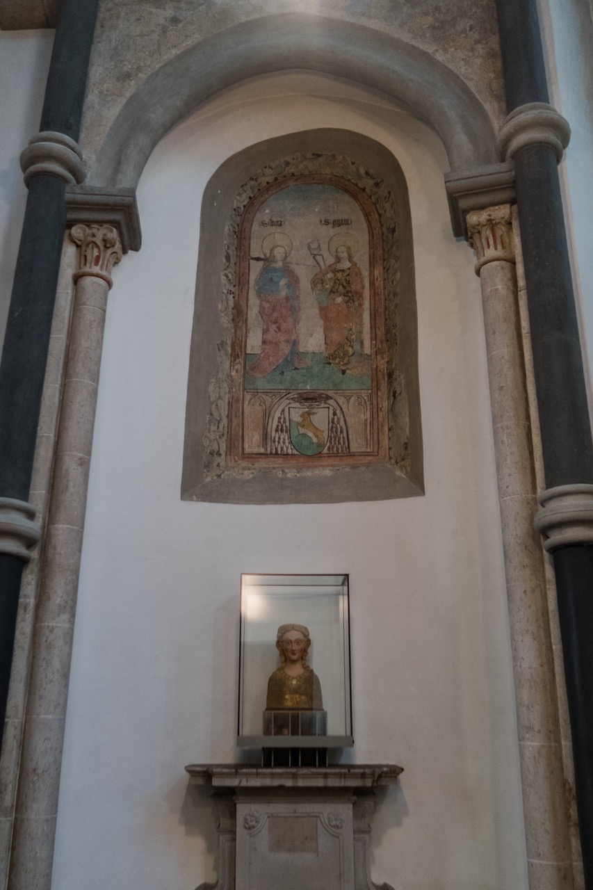Fresko der Hl. Lucia und Agata in einem zugemauerten romanischen Fensterbogen