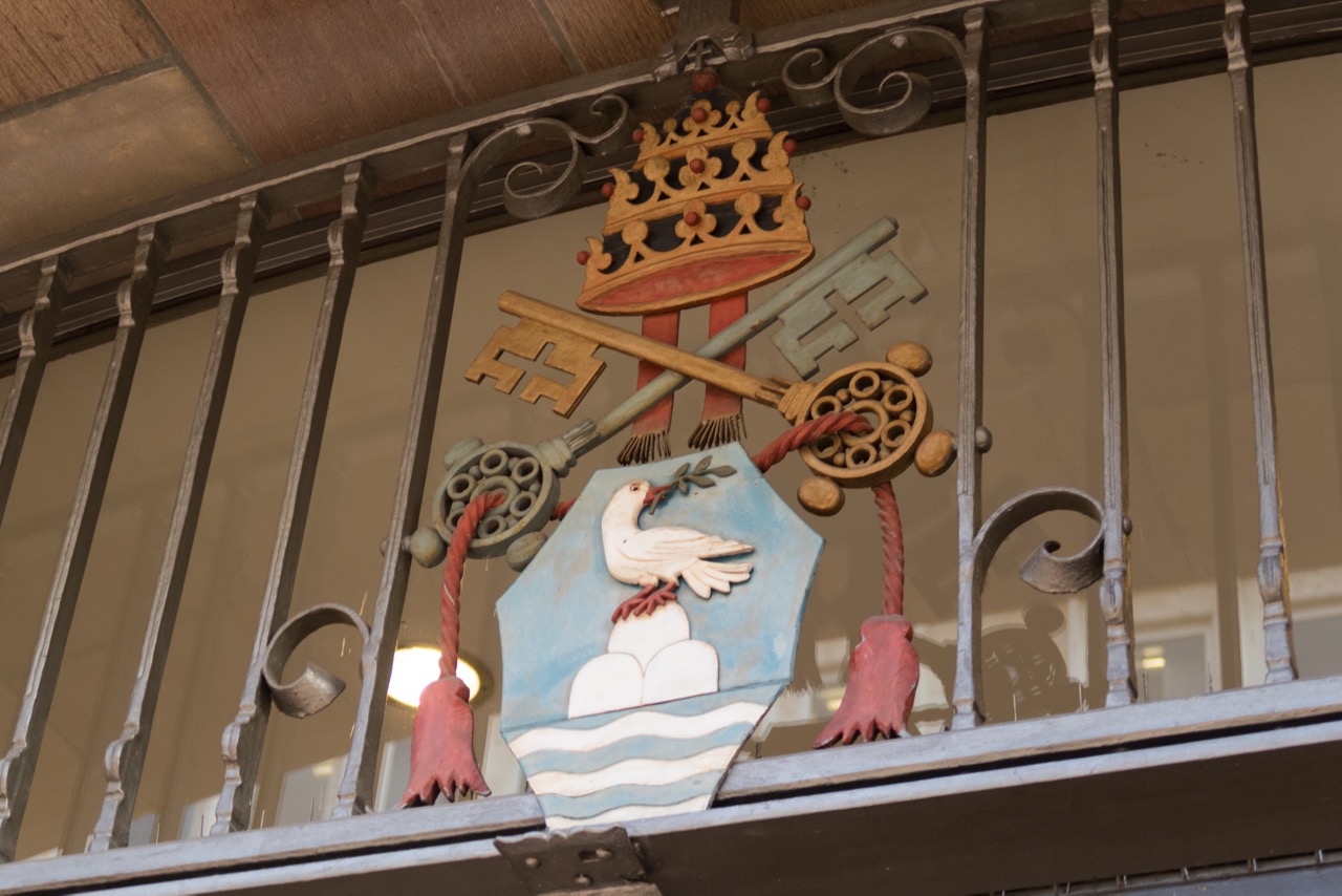 Wappen über dem Eingang von Papst Pius XII., der zur Zeit der Weihe der Kirche regierte