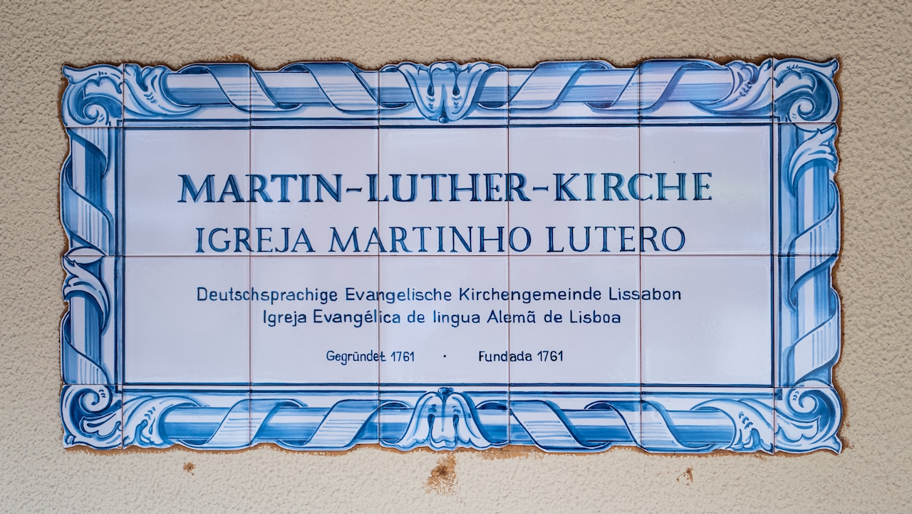 Schild an der Kirchenwand aus glasierten Fliesen („Azulejos“)