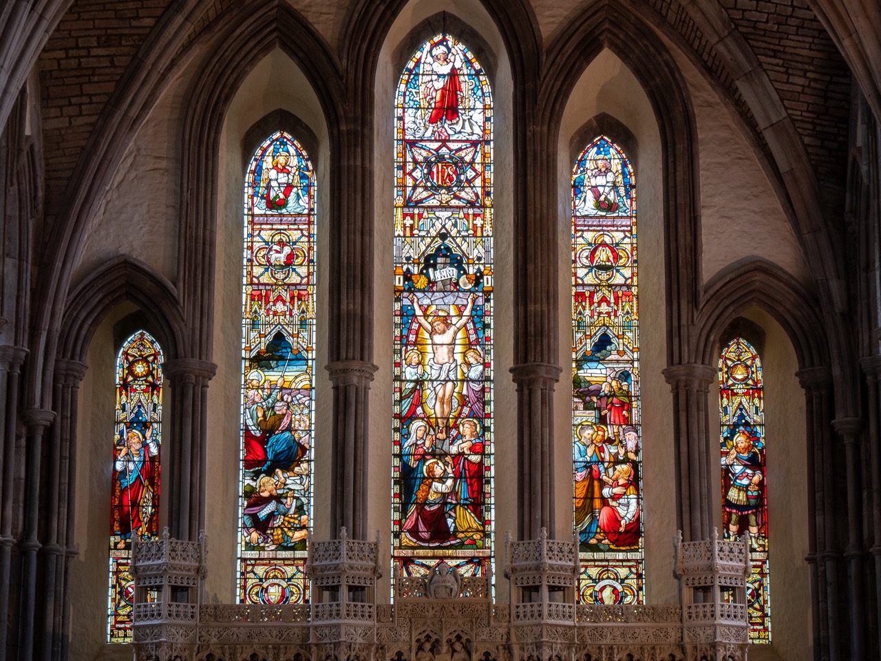 Stained glass windows in the choir with a crucifixion scene