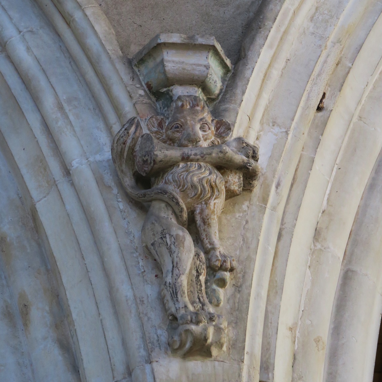 Corbel figure of a lion with a bone